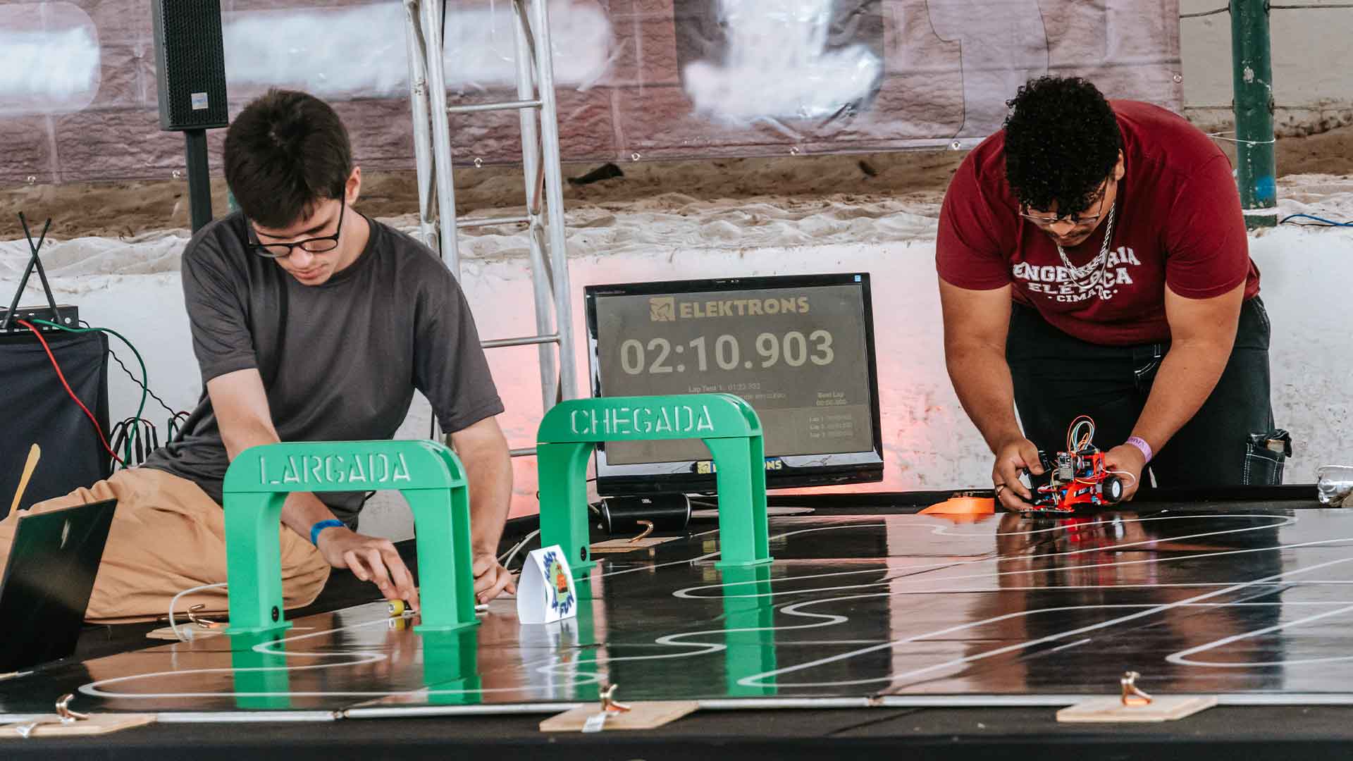 Dois pequenos robôs de combate em uma arena escura